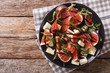 Gourmet salad with figs, prosciutto, blue cheese and arugula. horizontal top view
