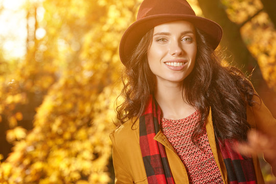 Sensual beautiful young woman in autumn park in a maroon hat
