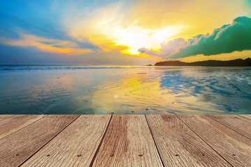 wooden plank at the beach with blurred of sunset time.