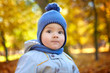© IVASHstudio - Portrait of little child in blue hat standing in autumn park