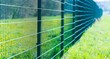 Metal fence in green field