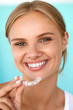 © puhhha - Smiling Woman With White Teeth Holding Teeth Whitening Tray. High Resolution Image