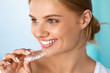 © puhhha - Smiling Woman With Beautiful Smile Using Teeth Whitening Tray. High Resolution Image