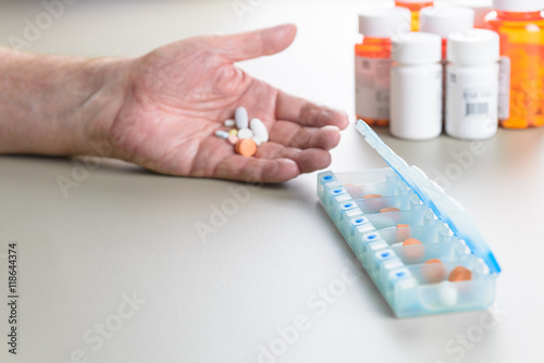 Fotografia Elderly man sorting daily medication into a pill box.