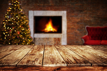 Wall Mural - christmas and new year background with empty dark wooden deck table over christmas tree and blurred 