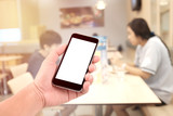 Fototapeta  - female hand holding the phone tablet on blur restaurant background