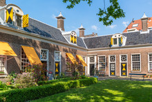 Green Courtyard Surrounded By Old Almshouses In Hofje Van Staats In City Of Haarlem, Holland, Netherlands