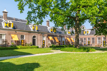 Wall Mural - Green courtyard surrounded by old almshouses in Hofje van Staats in city of Haarlem, Holland, Netherlands