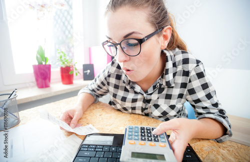 Obraz na plátne Woman calculating and paying bills in home office