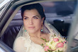 © pvstory - Beauty bride in bridal gown with bouquet and lace veil in the car. Beautiful model girl in a white wedding dress. Female portrait in the auto. Woman with hairstyle. Cute lady outdoors