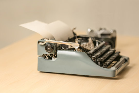 Retro typewriter on wooden table, blurred background