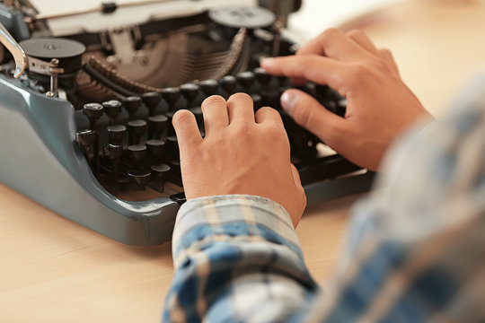 Man working on retro typewriter at desk