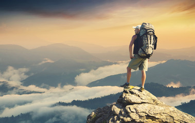 Wall Mural - Tourist on the peak of high rocks. Sport and active life concept..