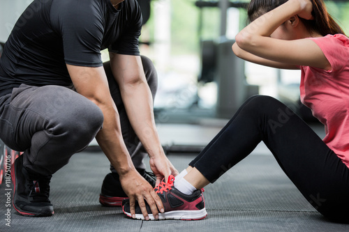 Fotografía Trainer holding a woman in the leg exercise by Sid-ups.
