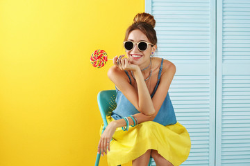 beautiful girl with candy on color background