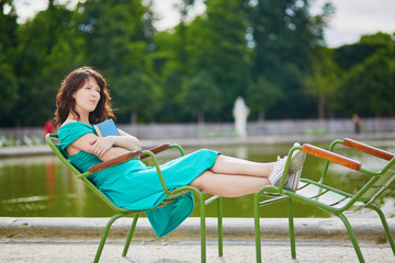 Wall Mural - Beautiful young woman relaxing in Parisian Tuileries park