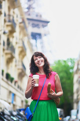 Wall Mural - French woman walking with coffee to go and baguette on a street of Paris