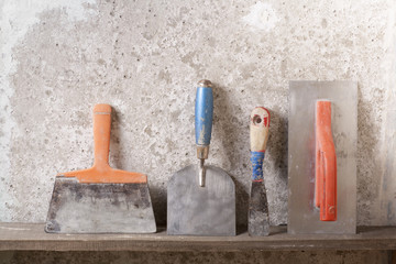 Construction tools on concrete background. Copy space for text. Set of assorted plaster trowel and spatula