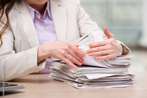 Fotografía Businesswoman working with stack of papers