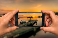 Taking Photo Of Sunset Over Lake With Mobile Phone