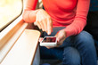 © kieferpix - Woman using her smartphone on a train.