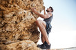 © Drobot Dean - Young man climbing natural rocky wall
