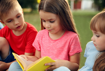 Wall Mural - Group of happy kids reading books in park