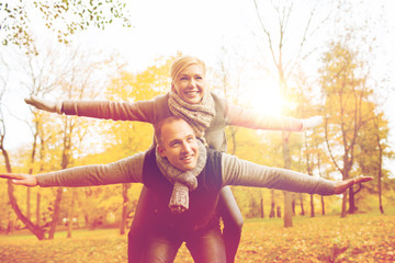 Canvas Print - smiling couple having fun in autumn park