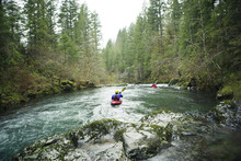 Two Men Kayaking In River
