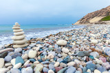Fototapeta Desenie - Pyramid of Stones near Sea on Beach