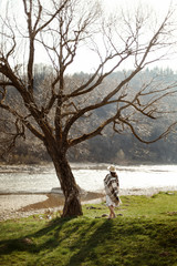 Canvas Print - beautiful woman hipster wearing hat and poncho walking at tree n