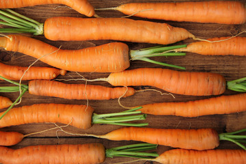 Fresh raw carrots on wooden table