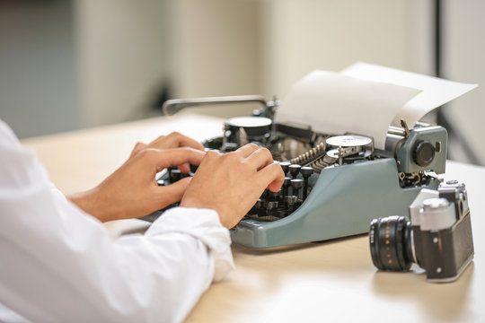 Man working on retro typewriter at desk