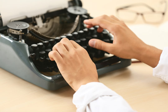 Man working on retro typewriter at desk
