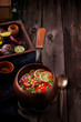Tomatoe mexican soup with spices and lime on wooden table