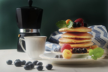 English fresh homemade pancakes with raspberries, blueberries, m