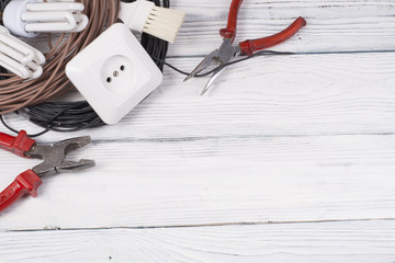 Wall Mural - Set of electrical tool on wooden background. Accessories for engineering work, energy concept.