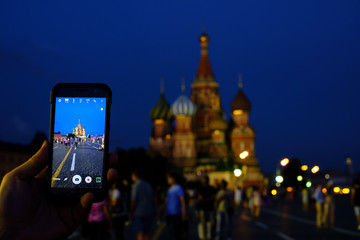 Male tourist taking picture of landmarks by smart phone at night