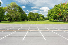 Empty Parking Lot Against Green Lawn In City Park