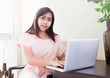 © pattarawat - young Asian girl working on laptop.
