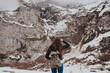 © Robert Marcillas/ADDICTIVE STOCK - Brunette traveler with backpack on winter landscape
