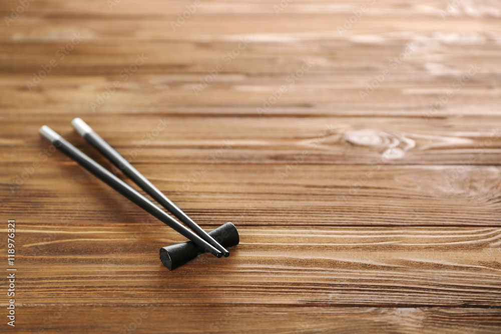 Black chopsticks on wooden background