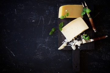 Parmesan cheese with basil on a dark background