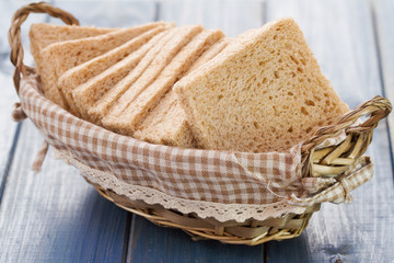 Poster - bread in basket on blue wooden background