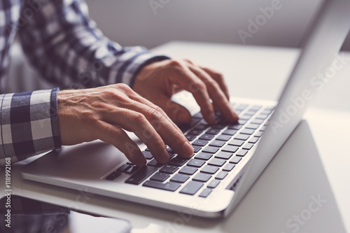 Plakat Mężczyzna pracuje na laptopie w biurze