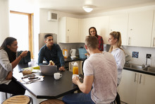 Students Relaxing In Kitchen Of Shared Accommodation
