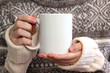 © maddyz - Girl in a warm sweater is holding white mug in hands.