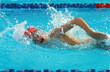 canvas print picture - Boy swimmer wearing red cap swim freestyle swimming stroke in a swimming pool