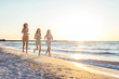 © kurapatka - three girls having fun on beach, friends on beach in sunset light