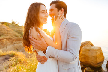 Wall Mural - Just-married couple standing at the beach